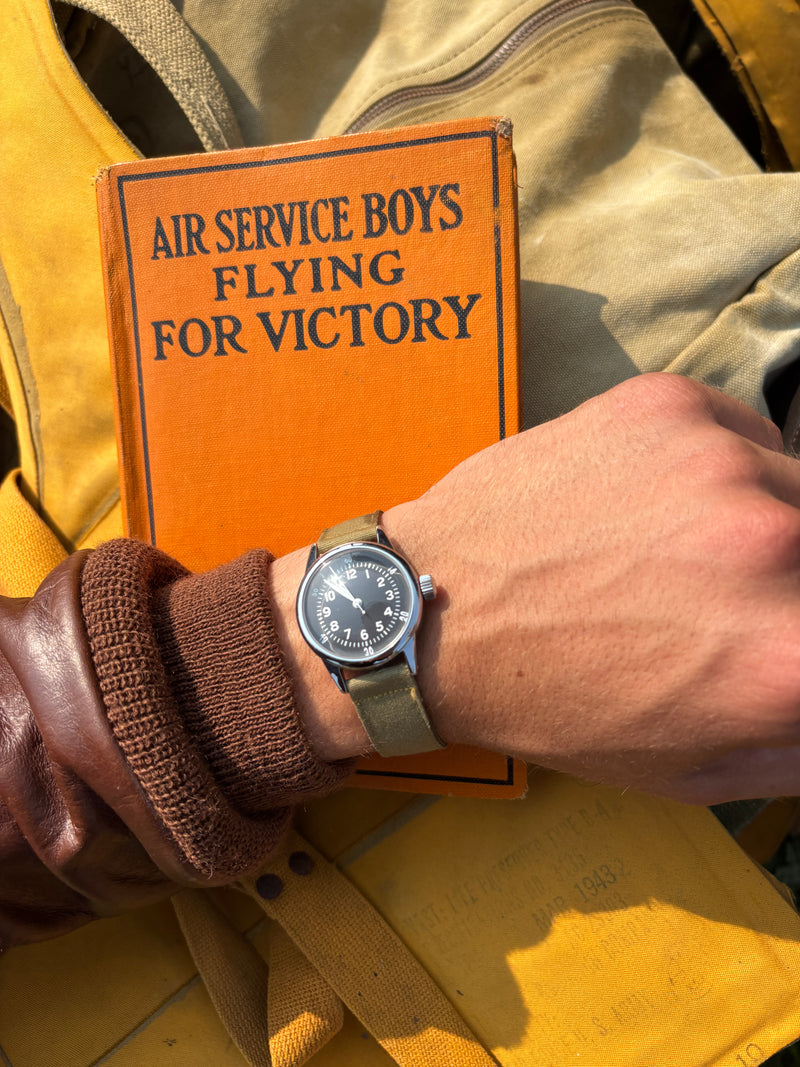 A Timeworn Watch with WWII memorabilia in the background.