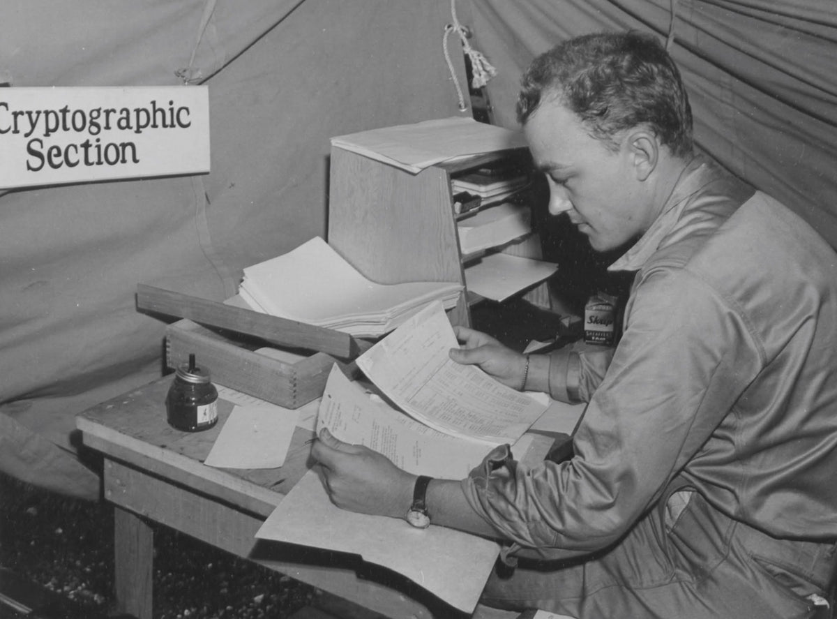 A historic photograph of a solider working at a desk wearing an Ordnance Department Wristwatch.