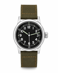 A wristwatch with a black dial, silver-tone case, and olive green canvas strap with tan stitching, shown on a plain white background.